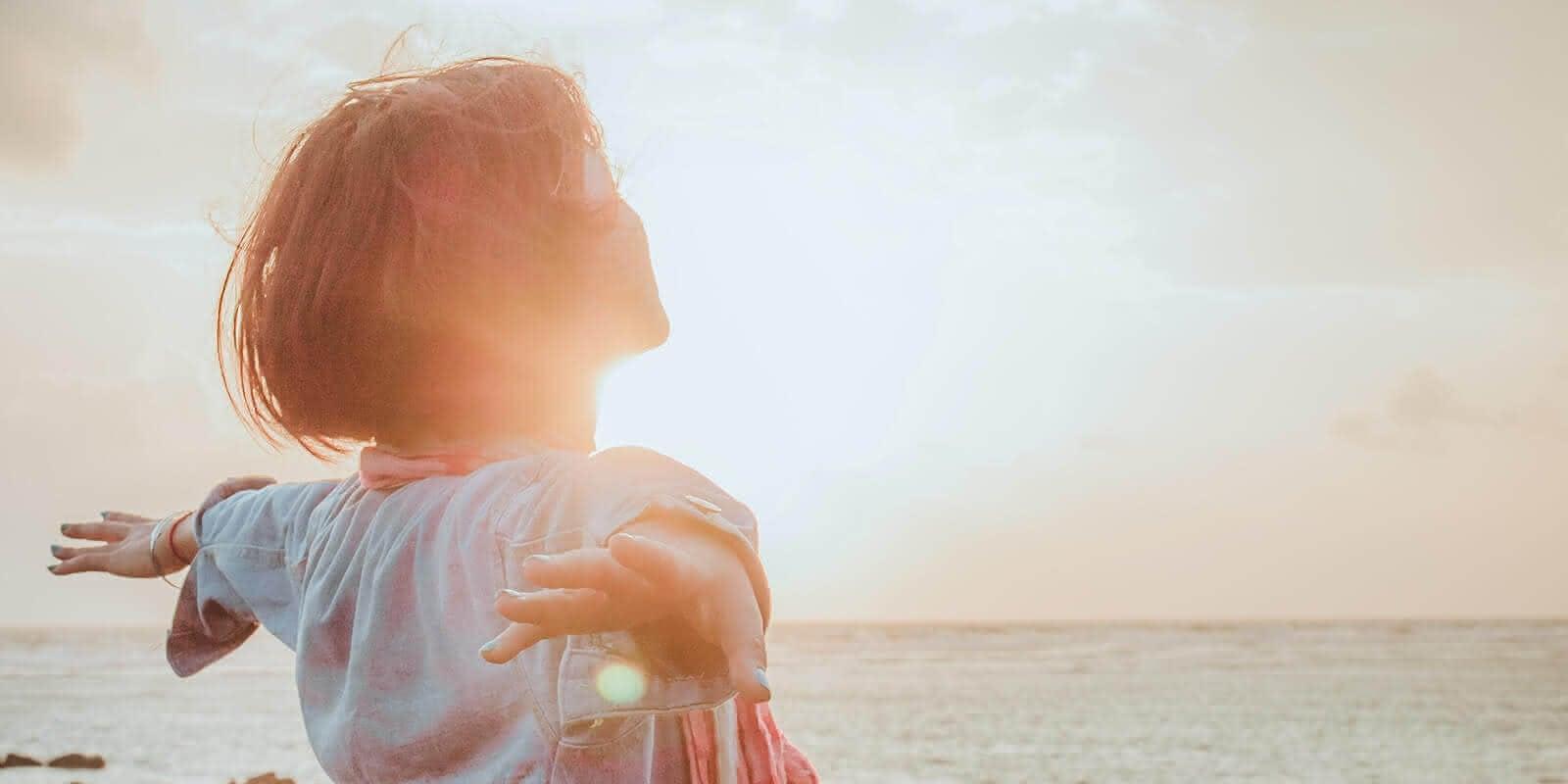 Junge Frau lässt sich die Sonne in das Gesicht scheinen